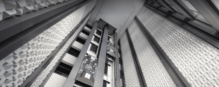 Technician monitoring elevator operations remotely using IoT software for real-time safety checks