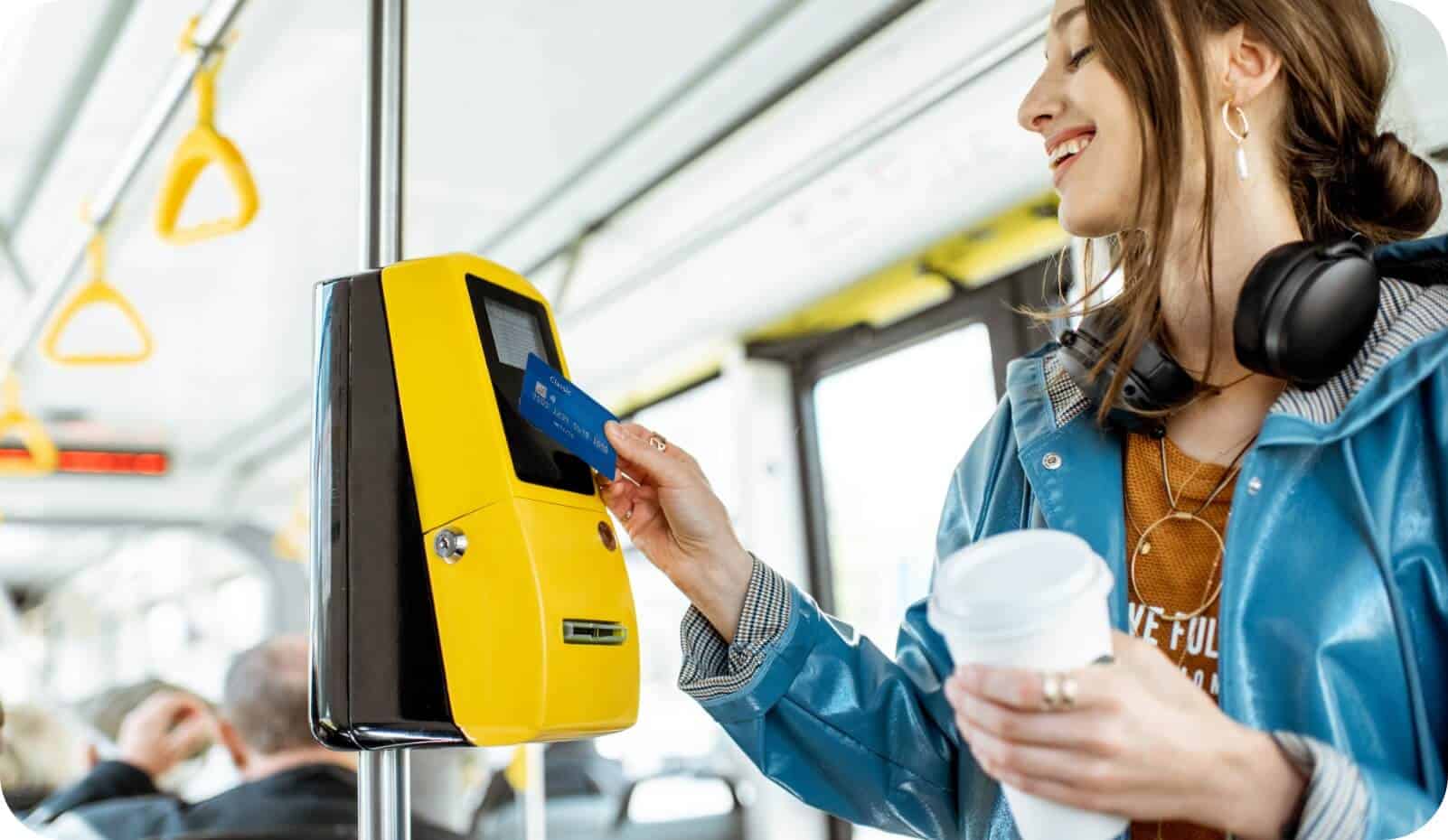 Une femme paie par carte dans un bus grâce aux solutions IoT InHand pour les transports en commun.