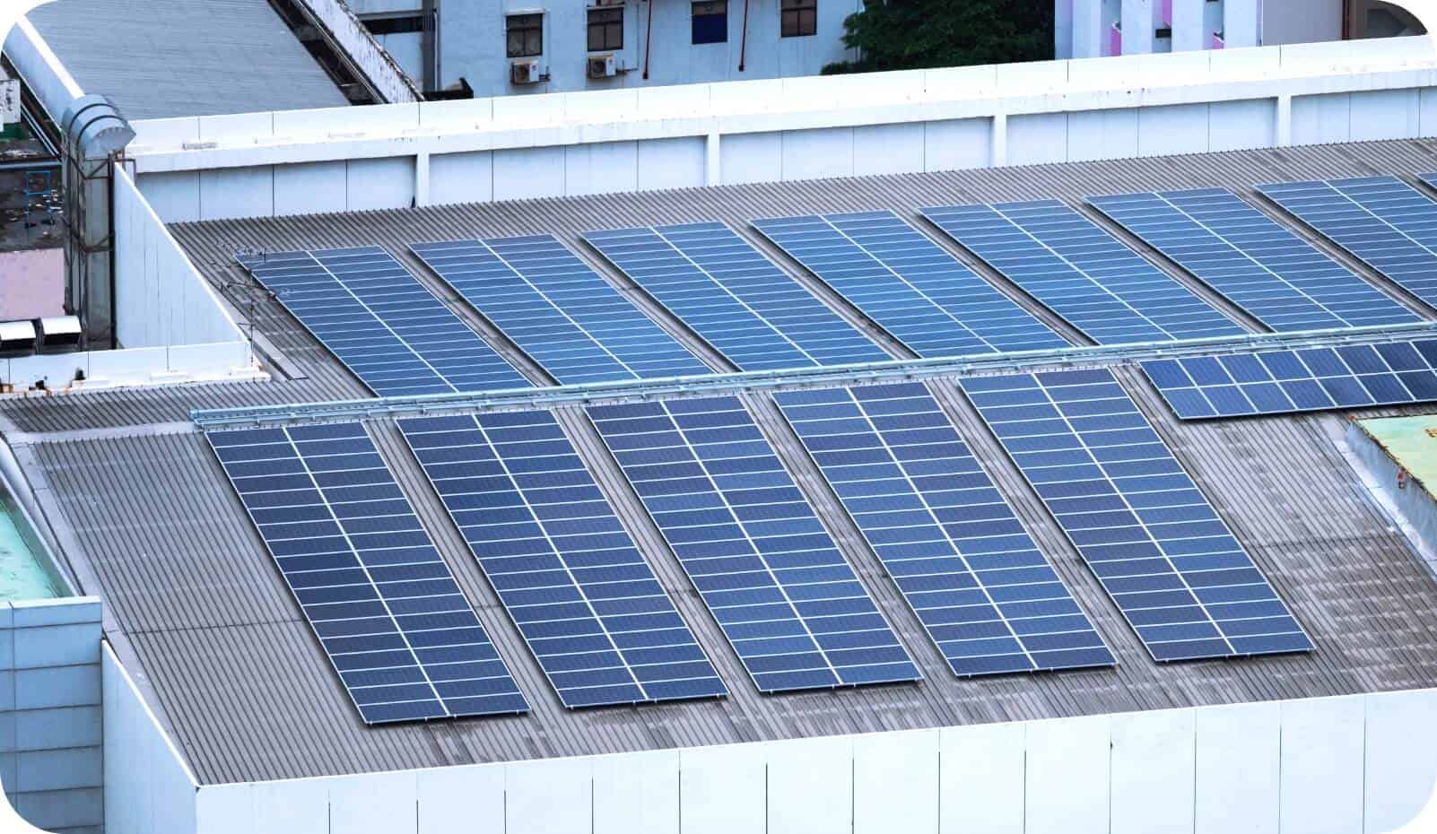 Row of solar panels on a city building roof, illustrating sustainable energy and efficient building management.