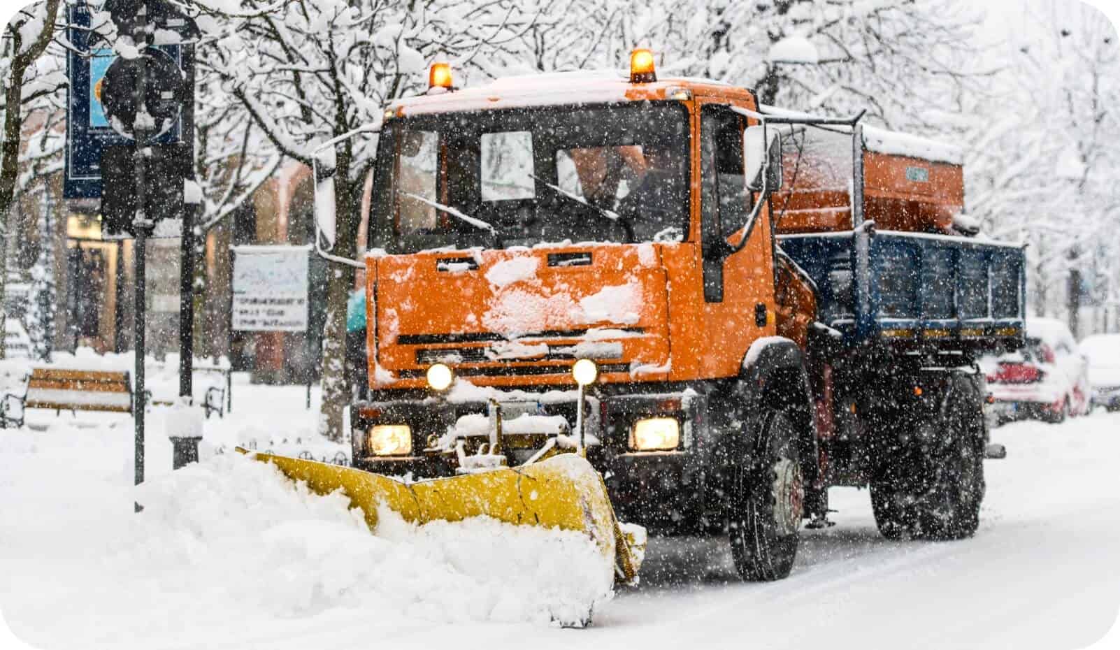 Une déneigeuse dégageant une rue de la ville illustre l'optimisation des opérations de la flotte municipale grâce à la technologie IoT.